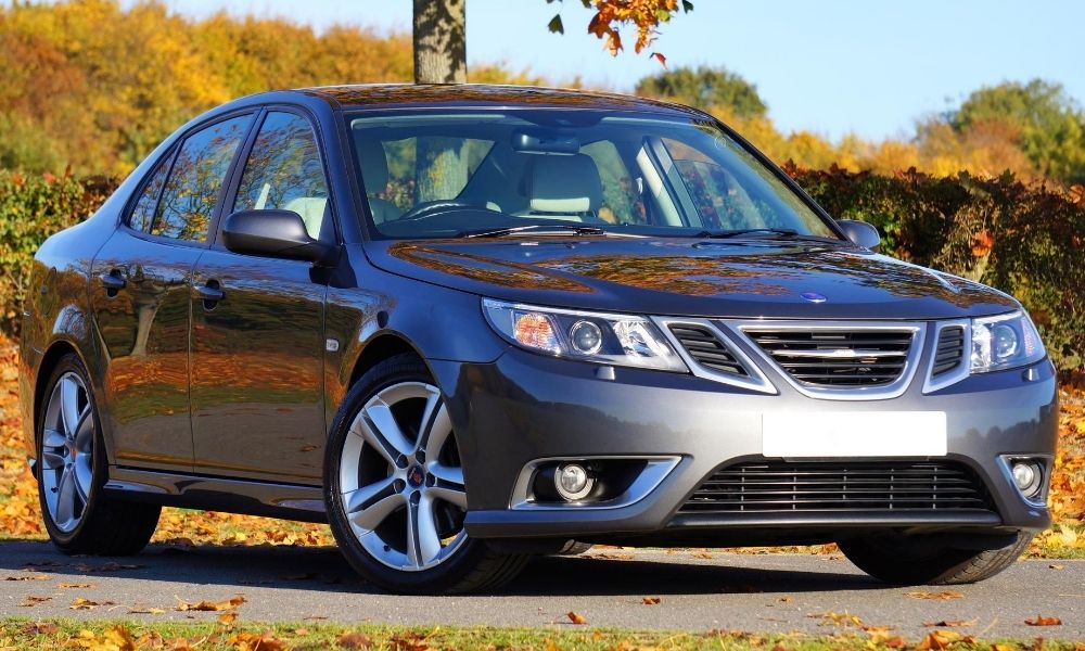 A car on a dirt road in autumn.