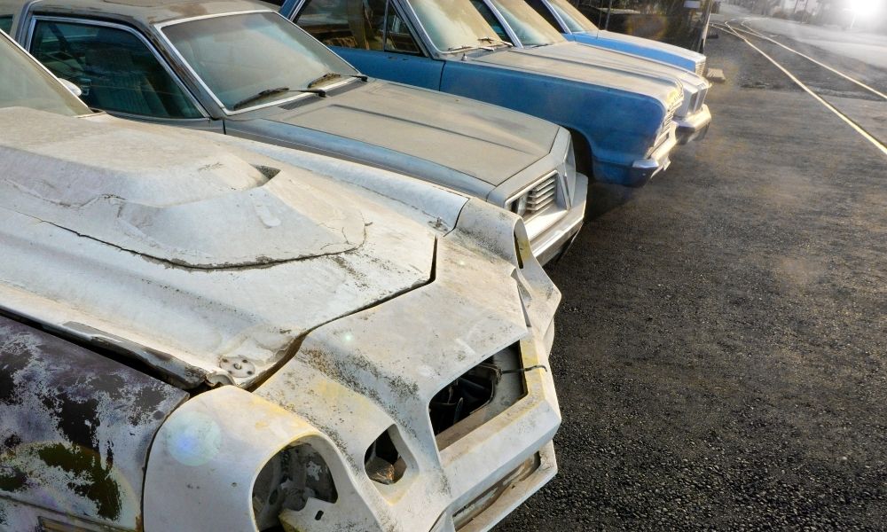 A lot of older, rusted cars. The cars have a vintage look.