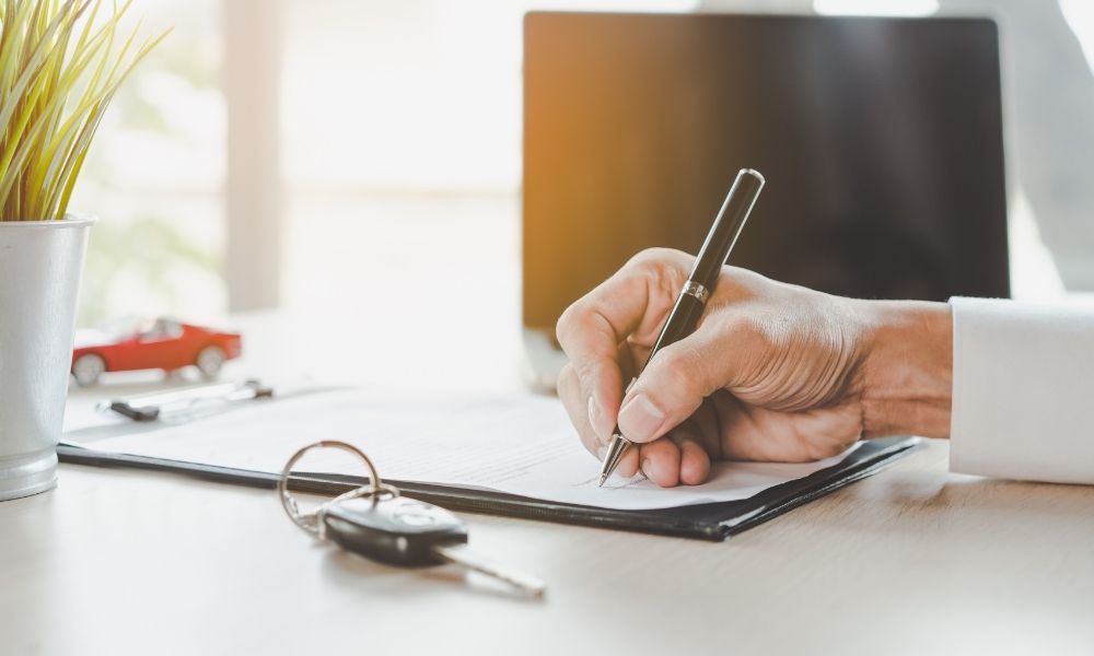 A man writing w/ an pen on a clipboard.