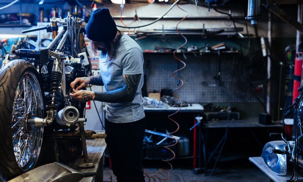 An auto shop technician working on a motorcycle.